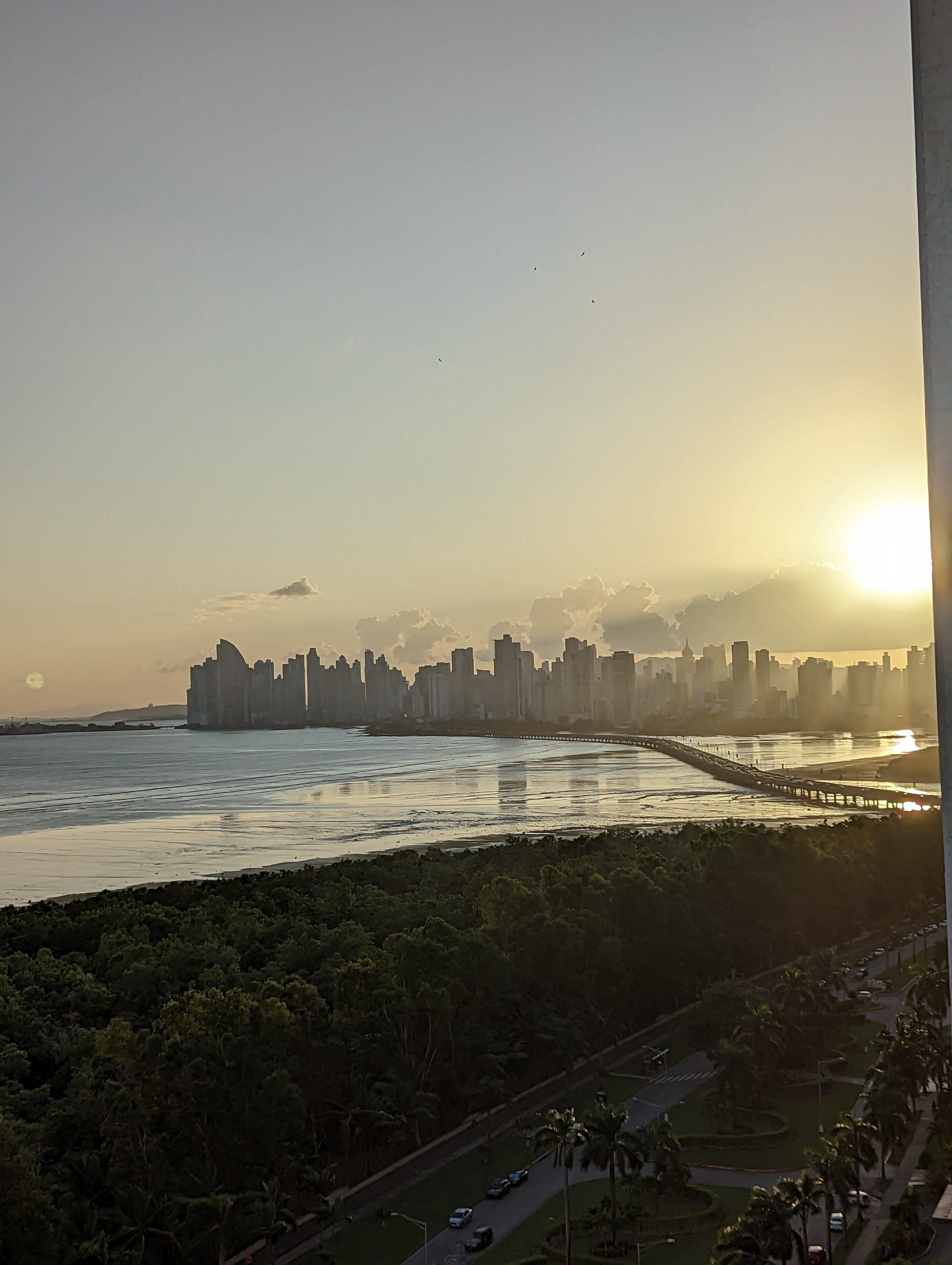A city skyline beneath a brilliant golden sunset.