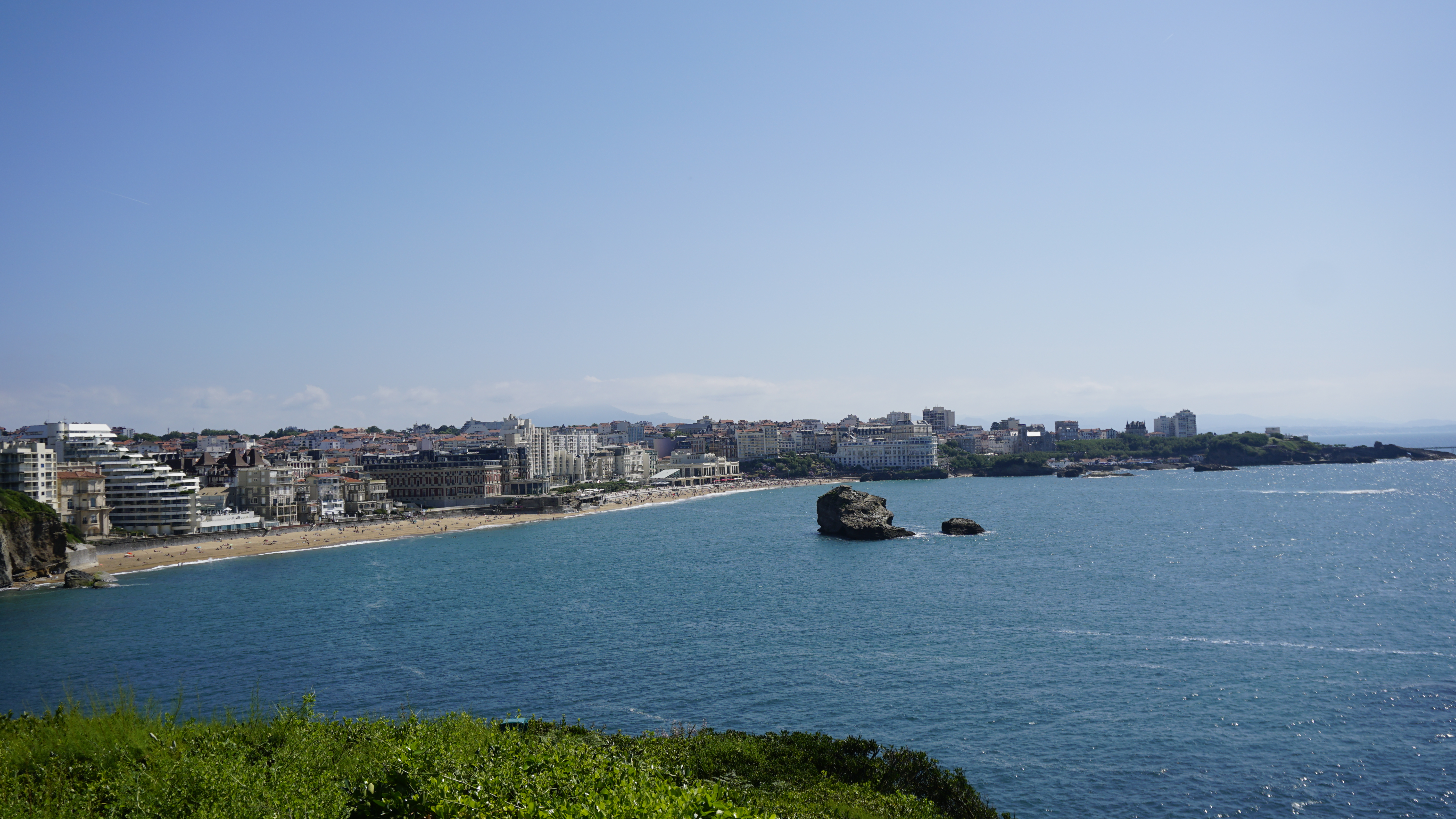 A sweeping seaside city, sandy beach and blue bay.